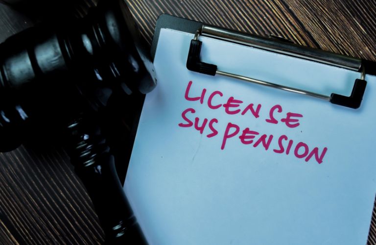 gavel and the words "license suspension" on a clipboard
